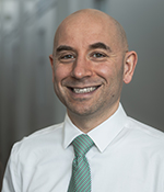 male in white button up shirt and green tie
